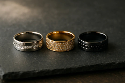 Men's diamond wedding bands in channel-set white gold, pavé yellow gold, and black-diamond black gold settings, arranged side by side