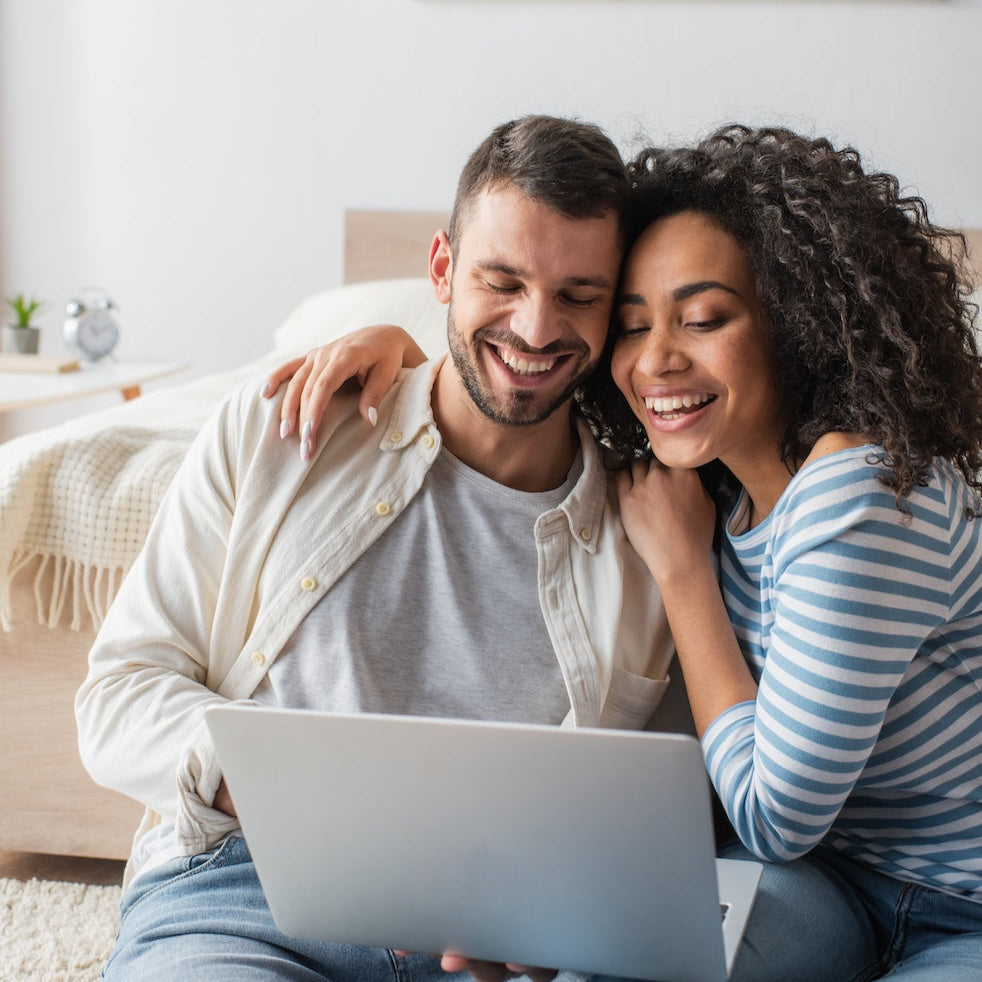 A Happy young couple sitting with a laptop 